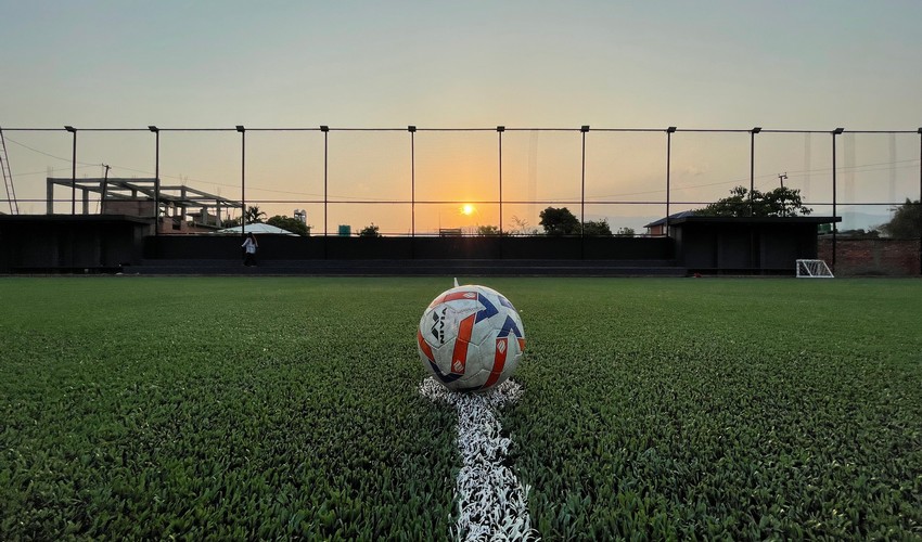 Two teams are playing in a football stadium